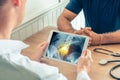 Doctor holding a digital tablet with x-ray of hips of the patient with pain on the spine Royalty Free Stock Photo