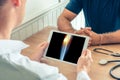 Doctor holding a digital tablet with x-ray of knee of the patient. Pain on the external knee Royalty Free Stock Photo