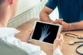 Doctor holding a digital tablet with x-ray of left hand of the patient. Osteoarthritis concept Royalty Free Stock Photo