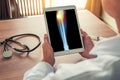 Doctor holding a digital tablet with x-ray of leg with pain on the external knee. Stethoscope and syringe on the desk Royalty Free Stock Photo