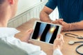 Doctor holding a digital tablet with x-ray of legs of the patient. Knee and ankle with pain Royalty Free Stock Photo