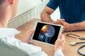 Doctor holding a digital tablet with x-ray of the skull head of the patient with pain on the brain. Cancer headache concept Royalty Free Stock Photo