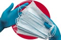 Doctor holds face masks in hands blue gloves on background national flag of Japan. Concept quarantine, hygiene, pandemic