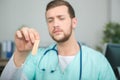 doctor holding forwards wooden tongue depressor