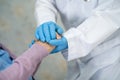 Doctor holding hand of Asian woman patient wearing blue glove ppe suit protect Covid-19 Coronavirus Royalty Free Stock Photo