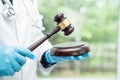 Doctor holding judge gavel, forensic medicine, medical law and crime justice concept