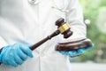Doctor holding judge gavel, forensic medicine, medical law and crime justice concept