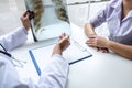 Doctor holding and looking at x-ray film examining at lungs radiograph of patient chest injury and analyze result while discussing