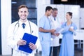 Doctor holding medical report and smiling at camera Royalty Free Stock Photo