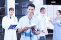 Doctor holding medical report and smiling at camera Royalty Free Stock Photo