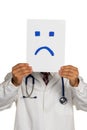 Doctor holding negative smiley face before