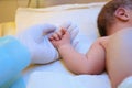 Doctor holding newborn child`s hand in hospital