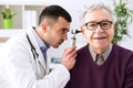 Doctor holding otoscope and examining patient ear