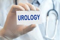 Doctor holding a paper card with text UROLOGY, medical concept