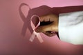 Doctor holding a pink ribbon in tribute to Breast Cancer patients