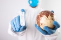Doctor holding the planet Earth and coronavirus test