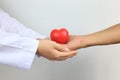 Doctor holding a red heart ball to Senior man on white background, Medicine and Health care concept Royalty Free Stock Photo