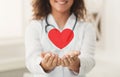 Doctor holding red heart in cupped hands Royalty Free Stock Photo