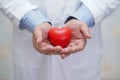 Doctor holding red heart in his hand in nursing hospital ward : healthy strong medical Royalty Free Stock Photo