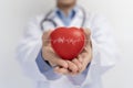 Doctor holding red heart shape in hand and modern medical network icon connected to virtual screen medical technology network