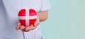 The doctor holding a red heart wrapped by white plus sign bandages like a gift isolated on light blue background with clipping Royalty Free Stock Photo