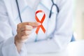 Doctor holding a red ribbon calling for safe sex and protection from AIDS Royalty Free Stock Photo