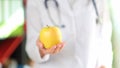 Doctor holding ripe yellow apple in hand Royalty Free Stock Photo