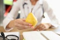 Doctor holding ripe yellow pear in hand Royalty Free Stock Photo