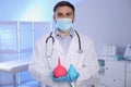 Doctor holding rubber enemas in room