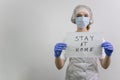 Doctor girl holding a `stay home` sign. Encourages people to fight the coronavirus without violating the quarantine. Covid-19 viru