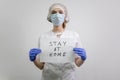 Doctor girl holding a `stay home` sign. Encourages people to fight the coronavirus without violating the quarantine. Covid-19 viru
