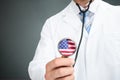 Doctor Holding Stethoscope With American Flag On Chestpiece