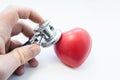 Doctor holding stethoscope in his hand, examines heart shape for presence of diseases of cardiovascular system. Photo for use in c