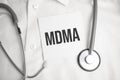 Doctor holding a stethoscope with text MDMA, medical concept