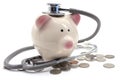 Doctor Holding Stethoscope to Piggy Bank Royalty Free Stock Photo