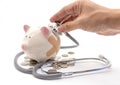 Doctor Holding Stethoscope to Piggy Bank Royalty Free Stock Photo