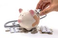 Doctor Holding Stethoscope to Piggy Bank Royalty Free Stock Photo