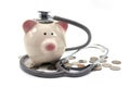 Doctor Holding Stethoscope to Piggy Bank Royalty Free Stock Photo