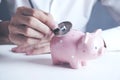 Doctor Holding Stethoscope to Pink Piggy Bank Royalty Free Stock Photo