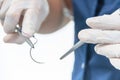 Doctor holding surgical forceps suture needle, suturing material Royalty Free Stock Photo