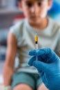 Doctor holding syringe subcutaneous vaccine for child in the medical office