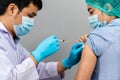 Doctor holding syringe and using cotton before make injection to nurse or Medical professionals in mask. Covid-19 or coronavirus Royalty Free Stock Photo