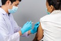 Doctor holding syringe and using cotton before make injection to senior patient in medical mask. Covid-19 or coronavirus vaccine Royalty Free Stock Photo