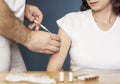 Doctor holding a syringe and vaccinating a woman a Royalty Free Stock Photo