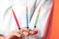 Doctor holding syringes full of liquids, closeup