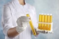 Doctor holding test tube with urine sample for analysis on blue background, closeup Royalty Free Stock Photo