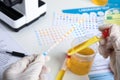 Doctor holding test tube with urine sample for analysis at white table Royalty Free Stock Photo