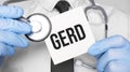 Doctor holdnd stethoscope and paper sheet woth text gerd. Medical concept Royalty Free Stock Photo