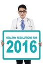 Doctor holds board with healthy resolutions for 2016 Royalty Free Stock Photo