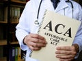Doctor holds a book Affordable care act ACA. Royalty Free Stock Photo